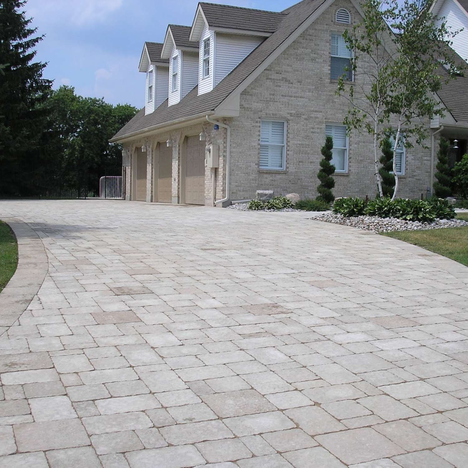 a large brick driveway in front of a house