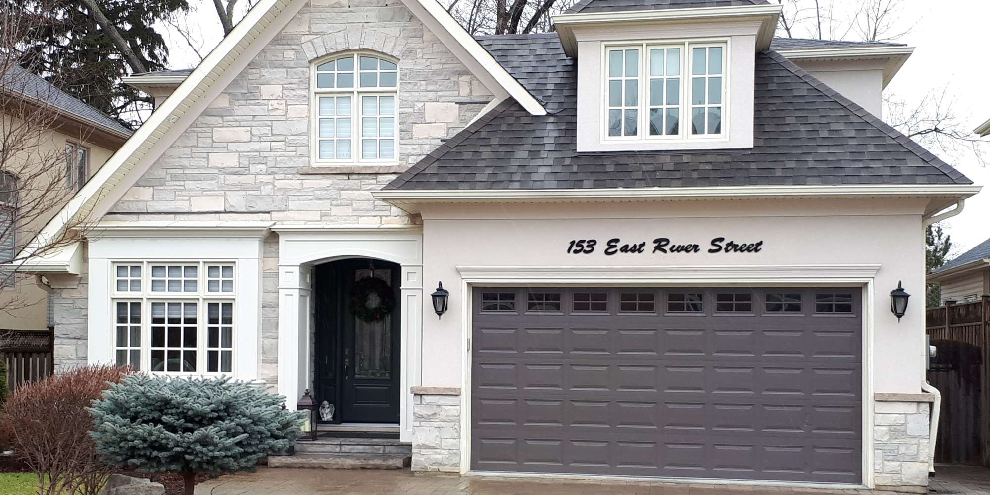 a gray and white house with a black door