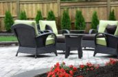 a patio with chairs and a table in the middle of it
