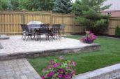 a patio with a table and chairs and flowers