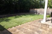 a backyard with a lawn and a grill