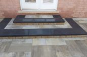 a paved area with two steps leading up to a door