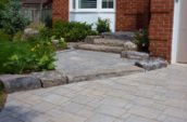 a brick patio with steps leading up to a house